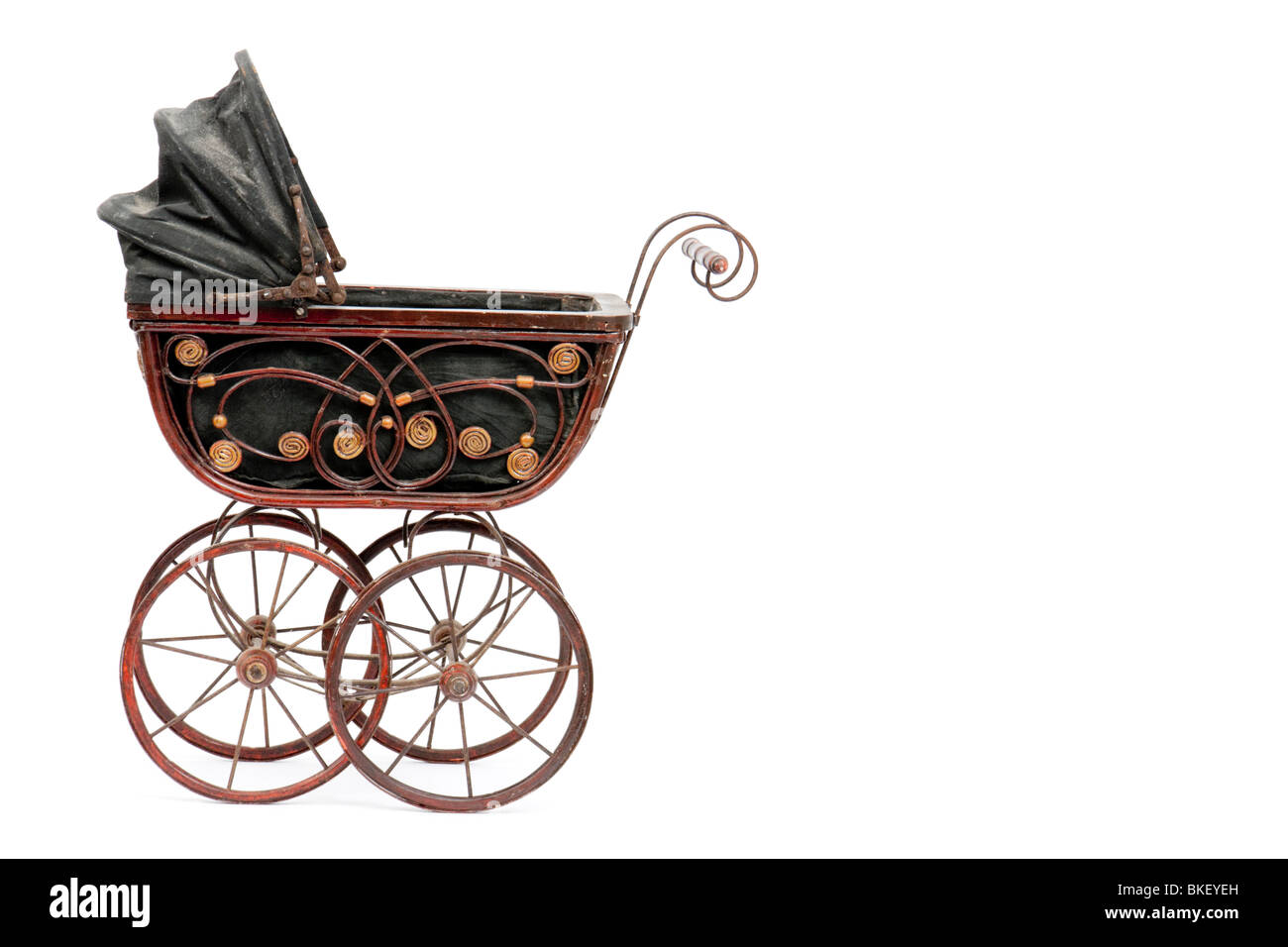 Rare antique Victorian wooden dolls pram with reversible hood, isolated on white background with empty space on right Stock Photo