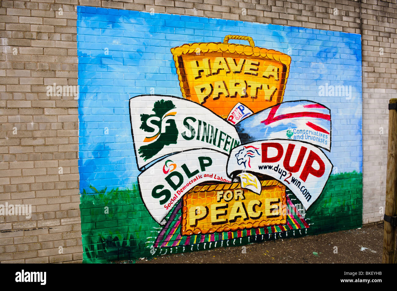 Mural on a wall with election banners for Sinn Fein, Ulster Unionist Party, SDLP and the Democratic Unionist party. Stock Photo