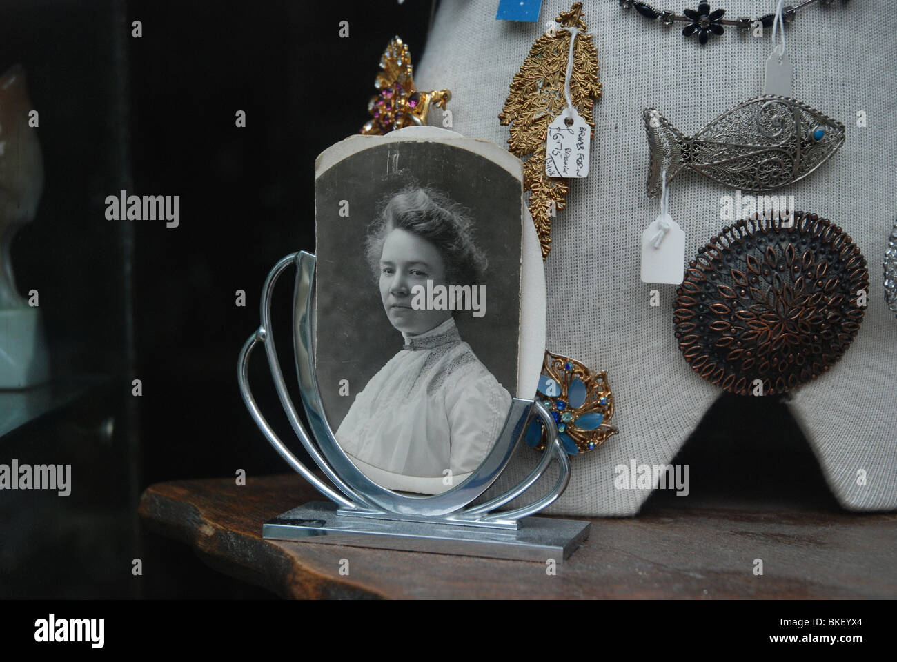 Black and white photograph of a Victorian woman on display in an antique/junk shop window. Stock Photo