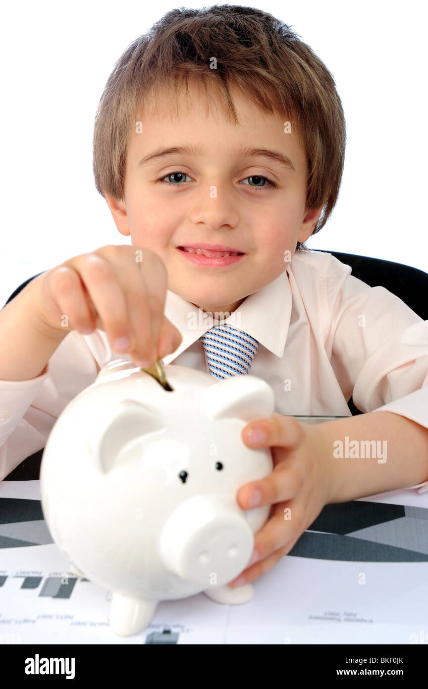Vertical image of a young boy putting money into his piggy bank Stock ...
