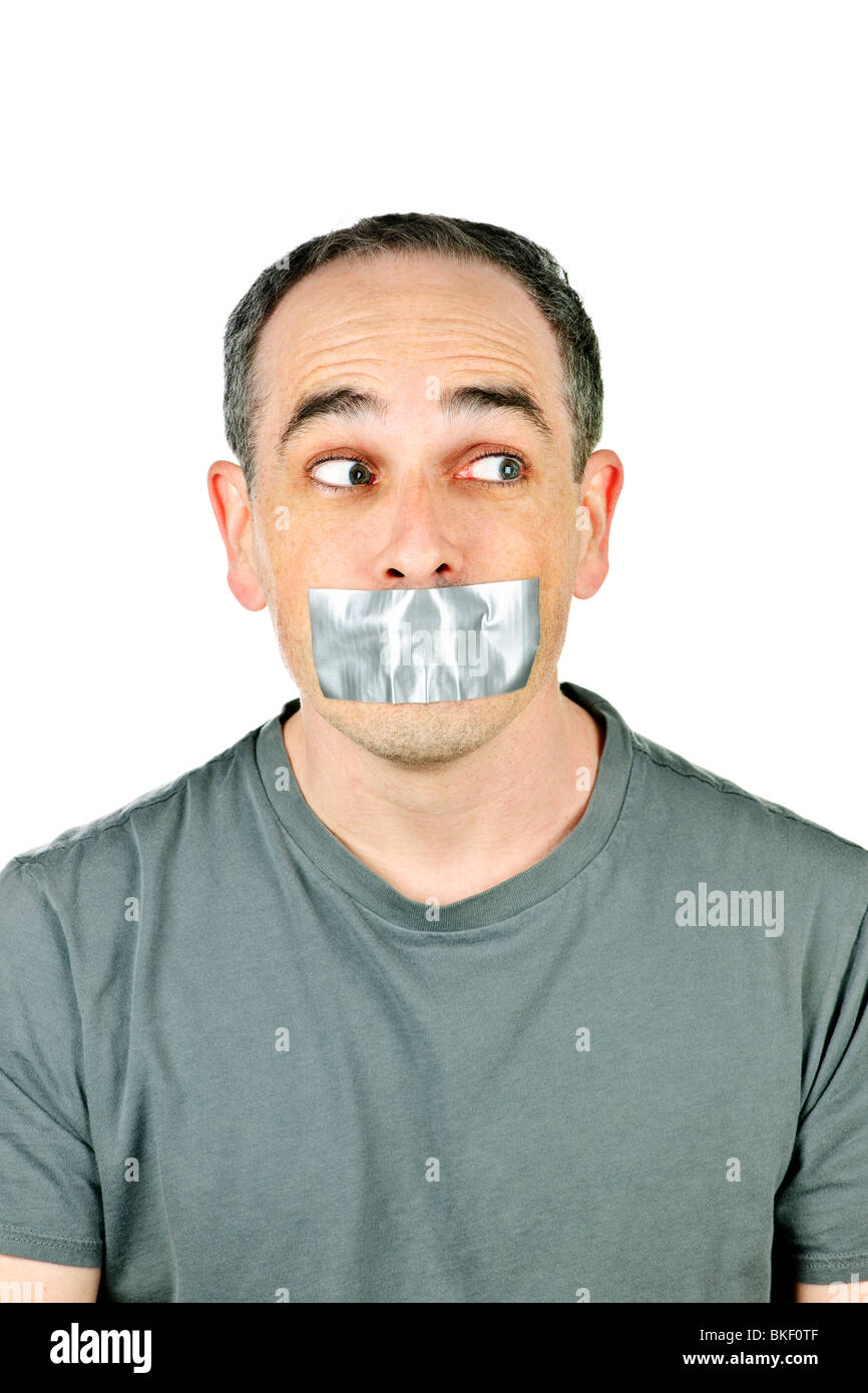 Portrait of man with duct tape over his mouth glancing sideways Stock