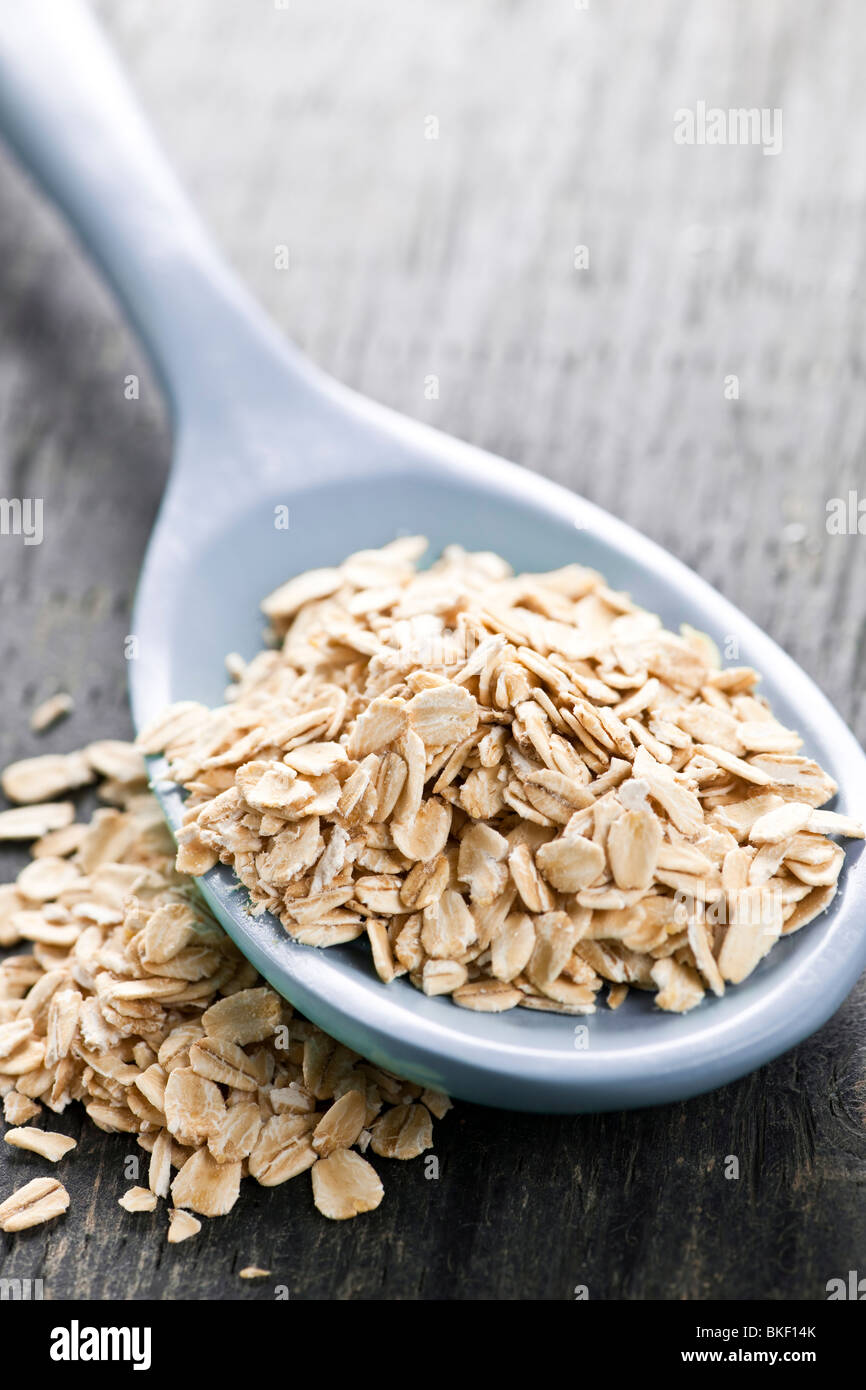 Nutritious rolled oats heaped on a spoon Stock Photo
