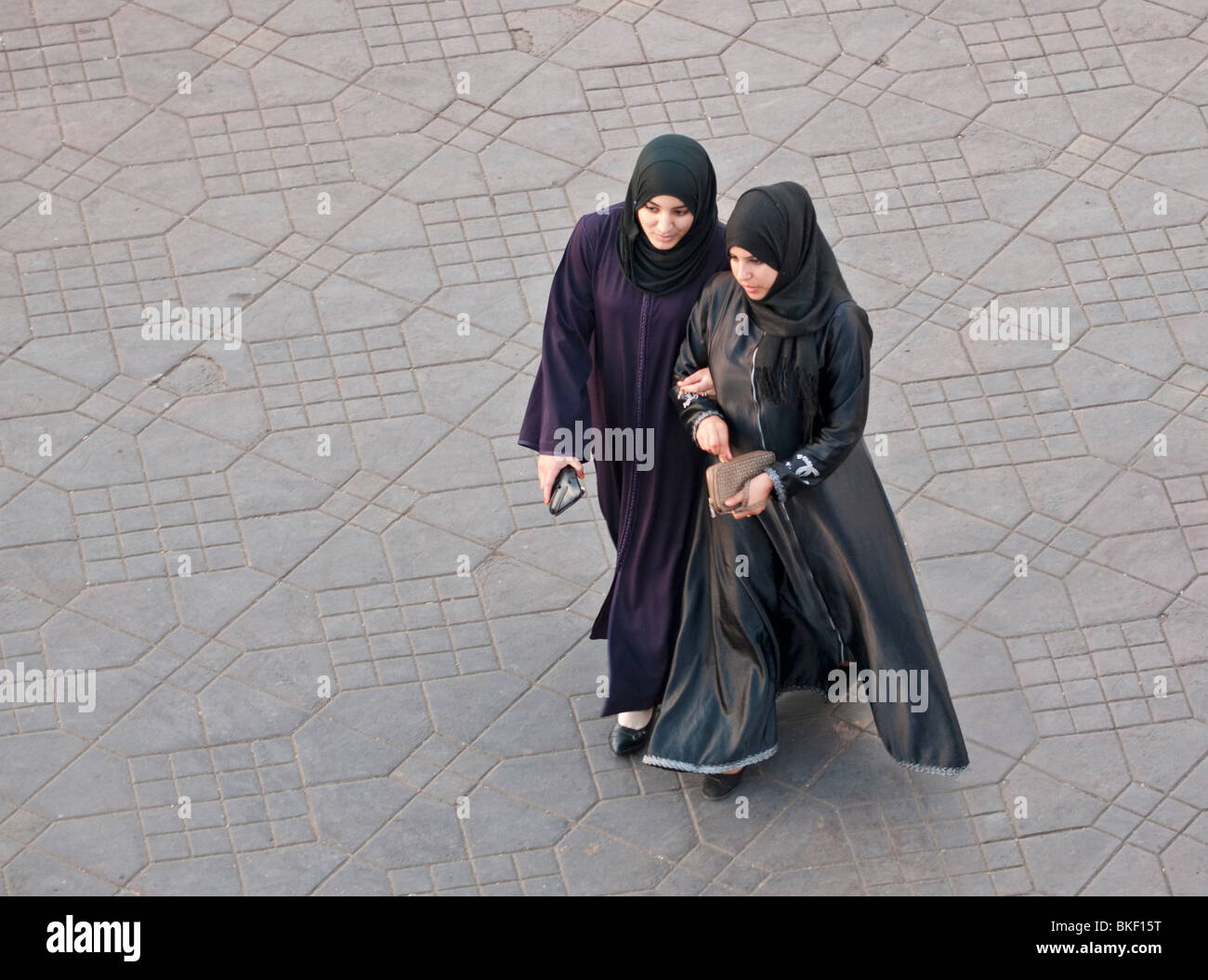 Two women walking in place Jemaa el-Fna in Marrakech, Morocco Stock Photo