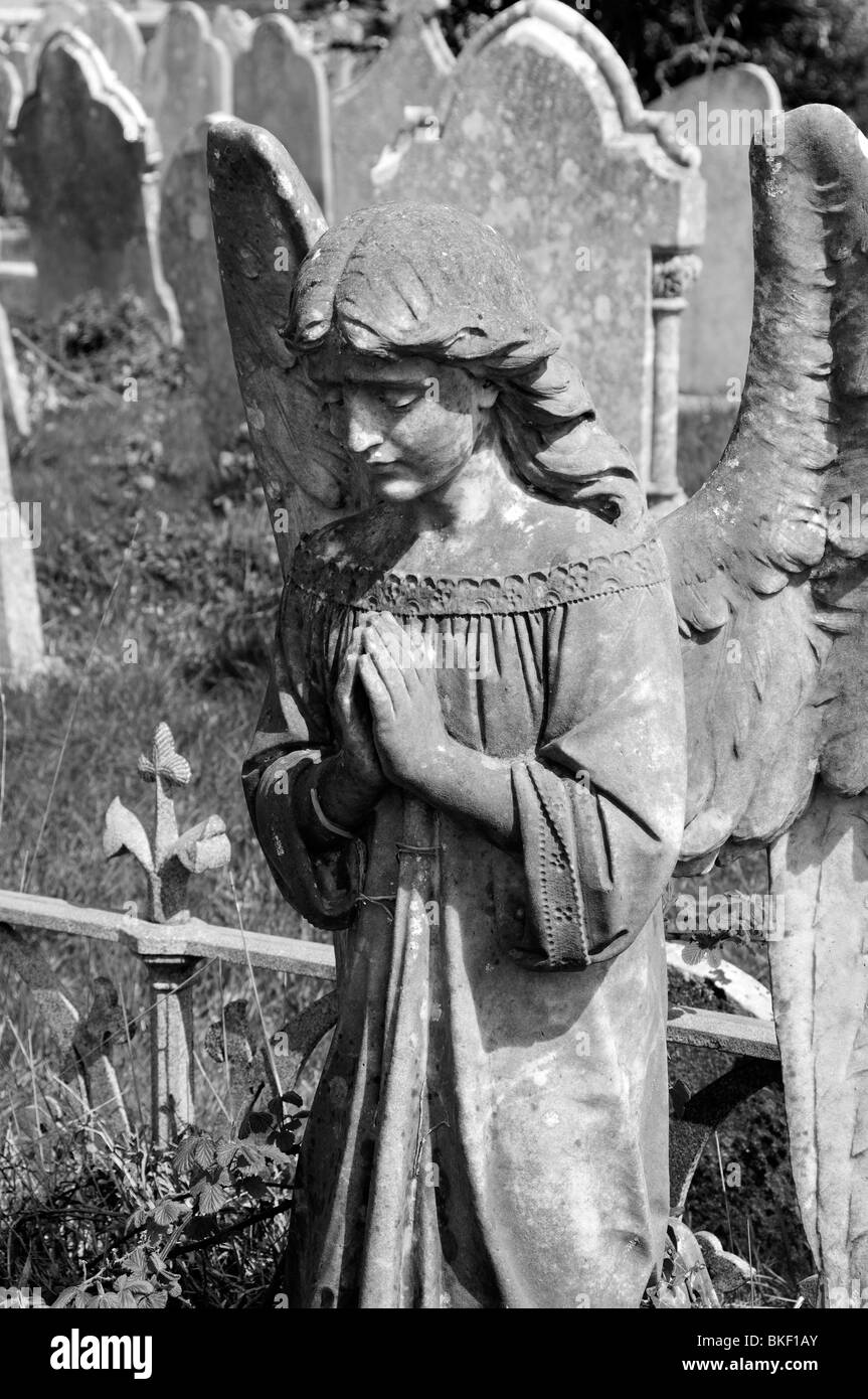 Winged Angel praying in a graveyard Stock Photo