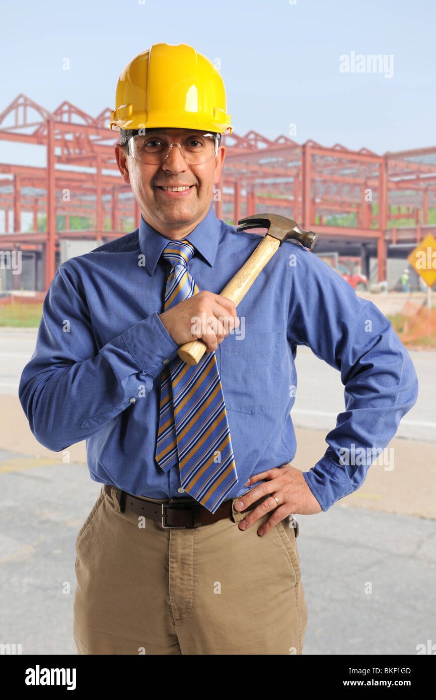 Hispanic construction manager with hammer at building site Stock Photo