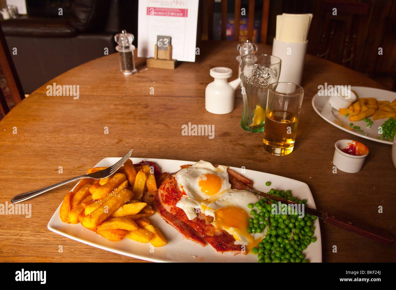Gammon , eggs , and chips inside The Rushbrooke Arms pub restaurant in Sicklesmere near Bury St Edmunds , Suffolk , England , UK Stock Photo