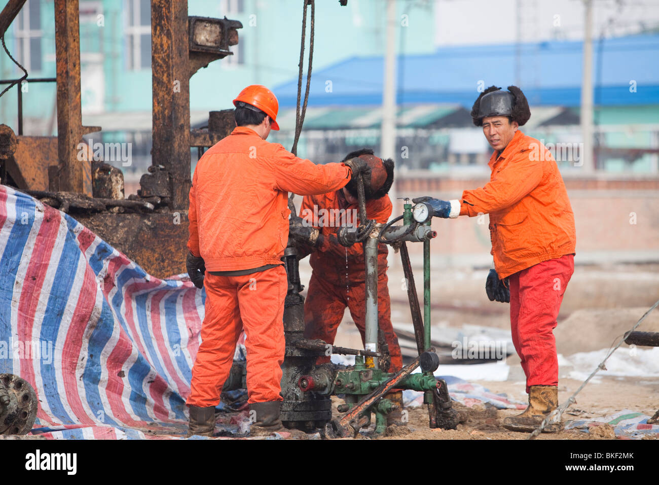 Oil workers drilling a new oil well in the Daqing oil field in Northern China Stock Photo