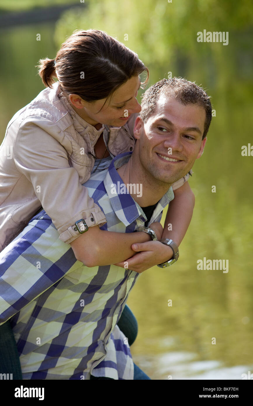 Handsome young couple doing a piggyback ride in the park Stock Photo ...