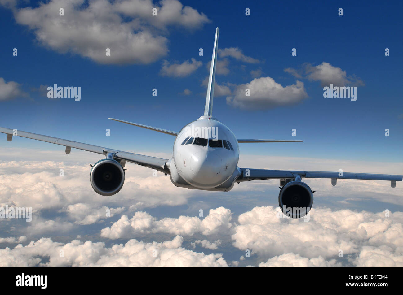 Commercial airliner in flight with clouds on the background Stock Photo