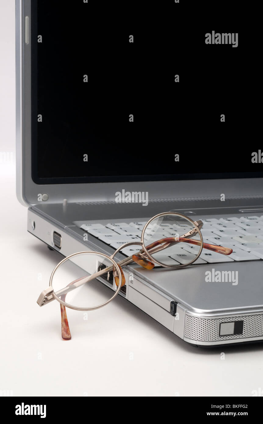 Reading eye glasses on a laptop computer on white Stock Photo