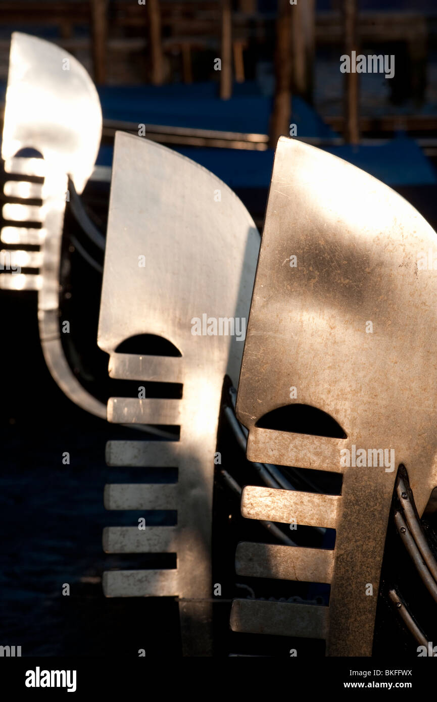 Evening sun reflecting off steel prows of Gondolas moored on Grand Canal in Venice Italy Stock Photo