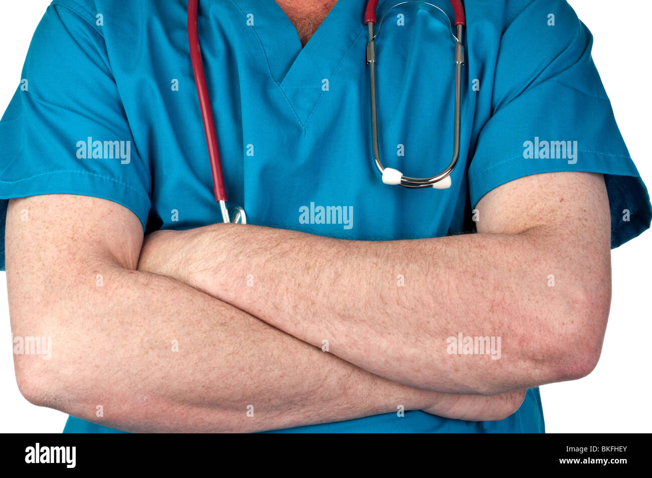 doctor with arms crossed in blue scrubs with a stethoscope Stock Photo