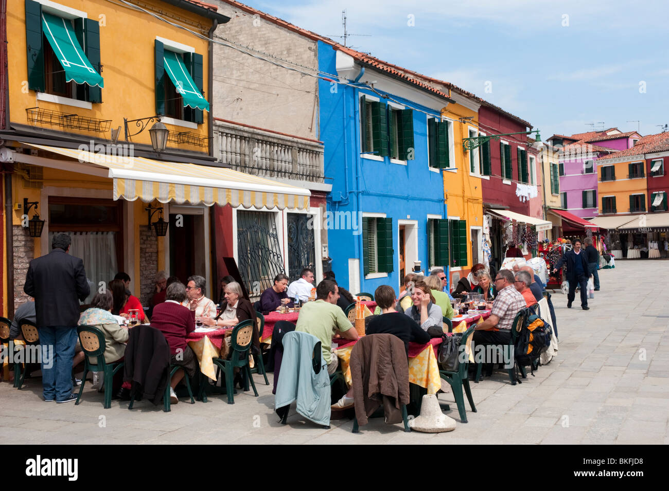Colourful houses  and outdoor restaurant in village of Burano near Venice in Italy Stock Photo
