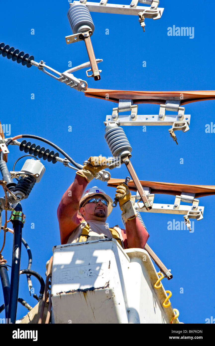 electrical power workers take safety seriously as they attach new bracket Stock Photo