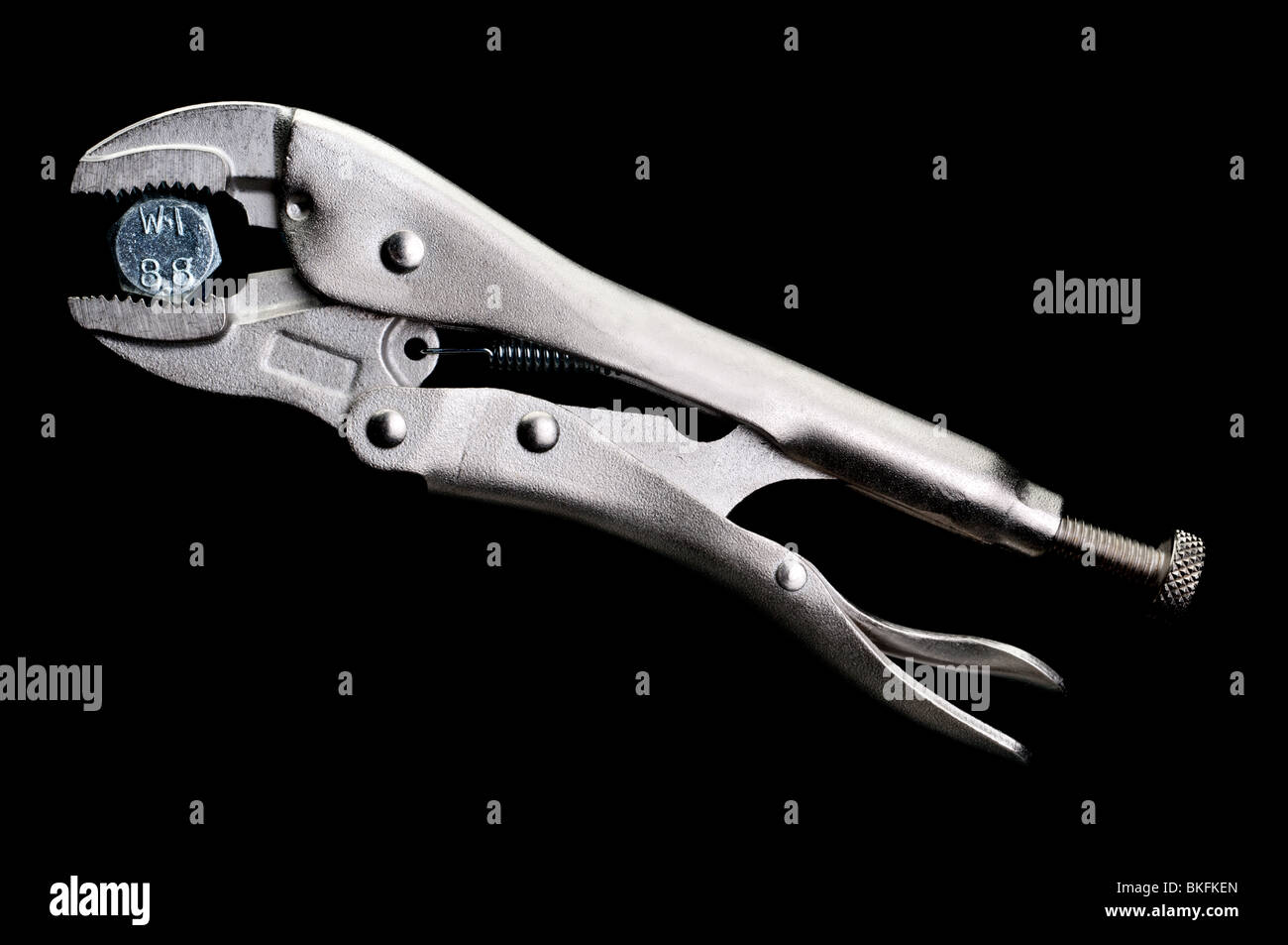 locking pliers locked on to a bolt on black Stock Photo