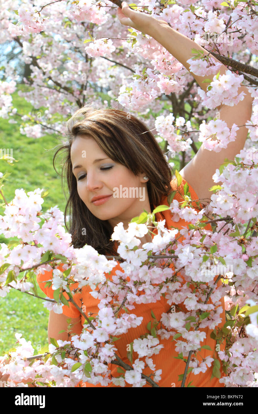 Happy young woman in the spring, blooming cherry tree, cherry blossoms Stock Photo