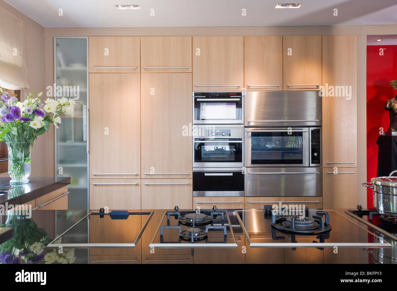 Gas hobs in fitted unit in modern kitchen with double ovens in wall of  fitted cupboards Stock Photo - Alamy