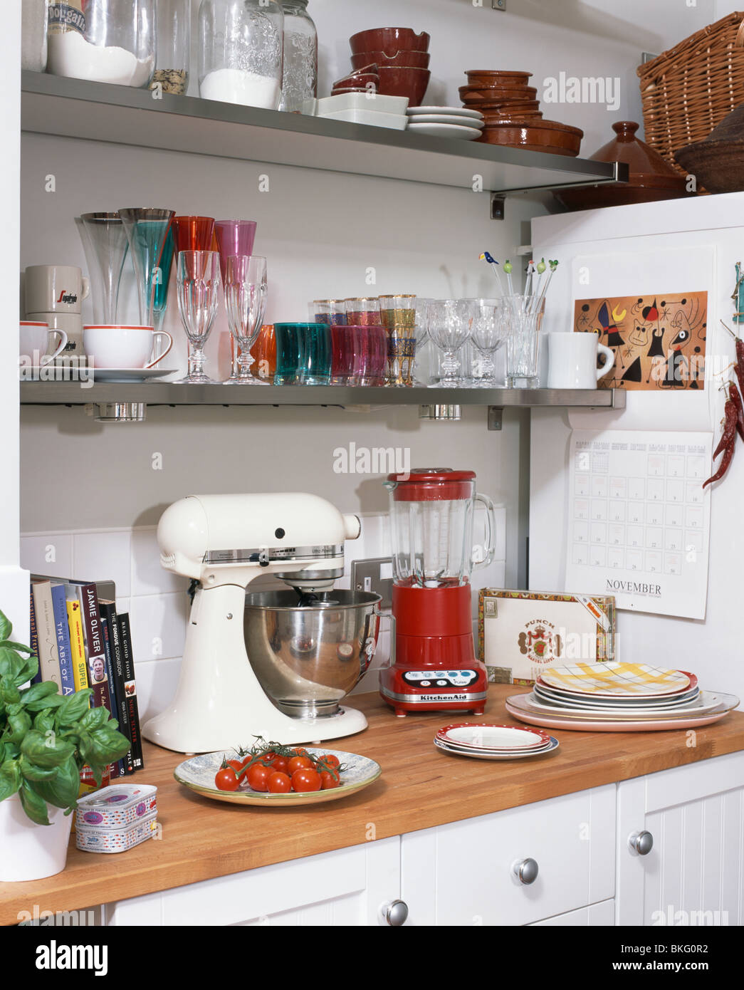 Close-up of red Kitchenaid blender and white Kitchenaid mixer on  kitchen worktop below storage shelves Stock Photo - Alamy