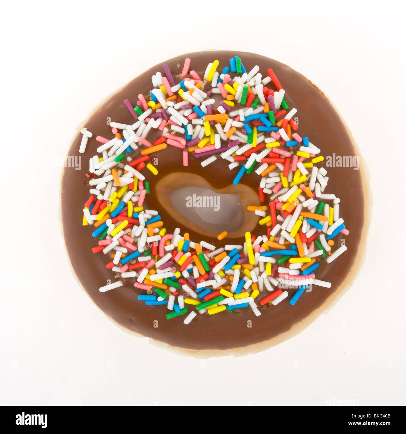 Chocolate Doughnut with vibrant multicoloured sprinkles isolated against white. Stock Photo