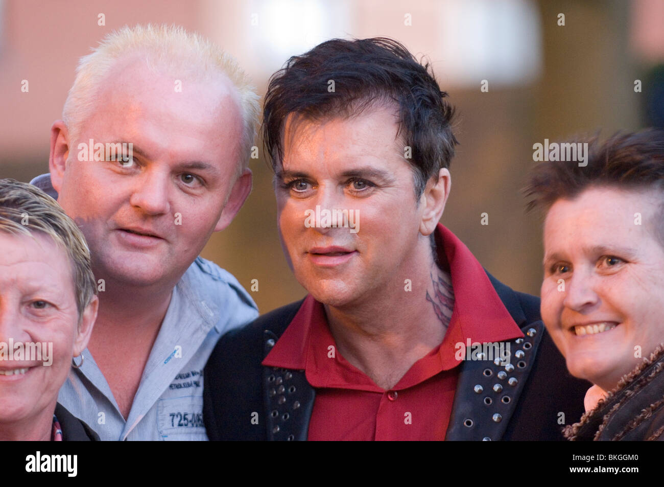 Fans pose for a photo with 80's band Visage lead singer Steve Strange