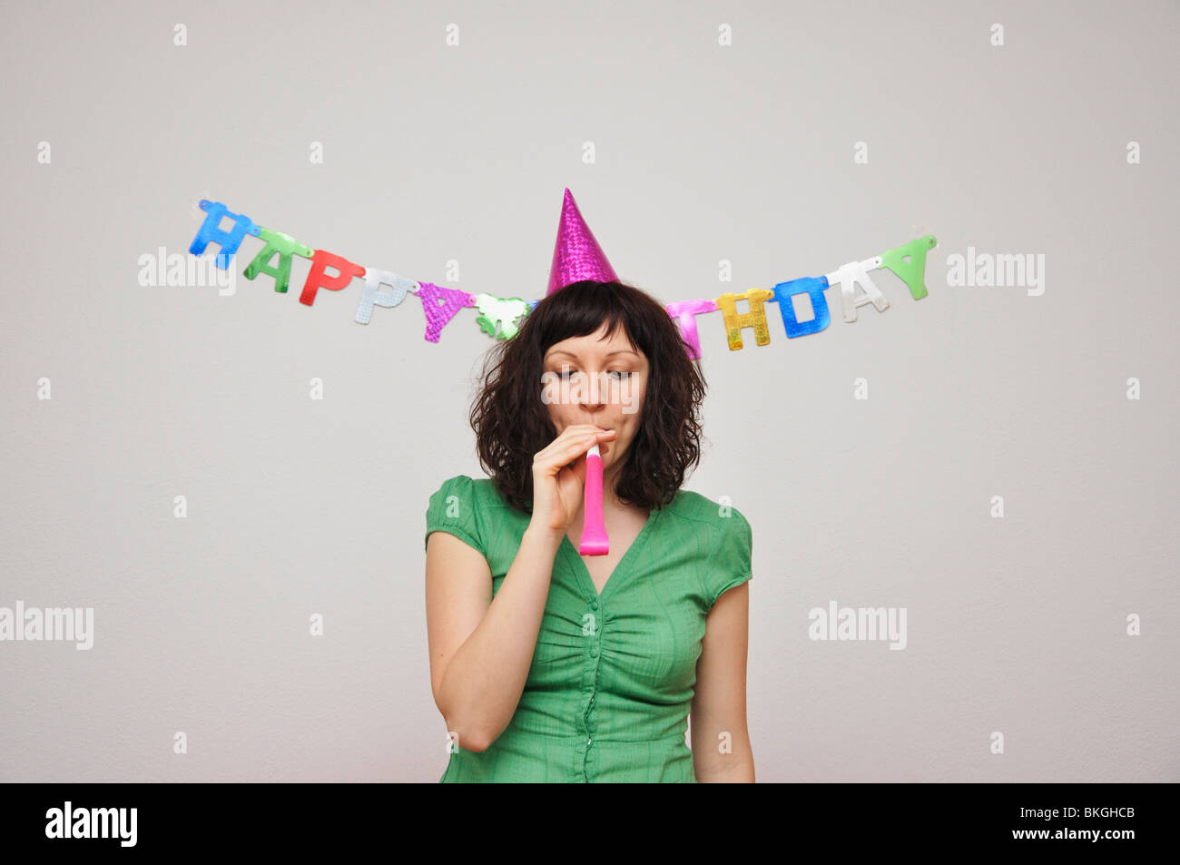 Young woman blowing noise blower Stock Photo - Alamy