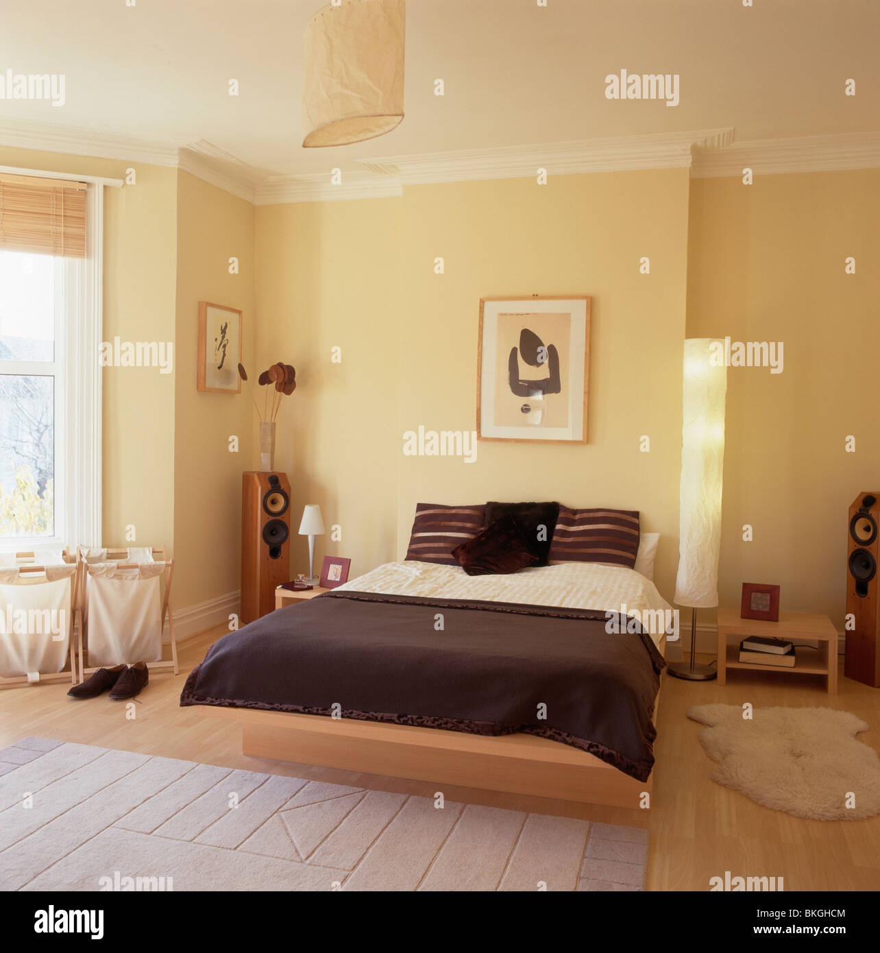 Dark gray bedcover on bed on small raised platform in modern economystyle bedroom with