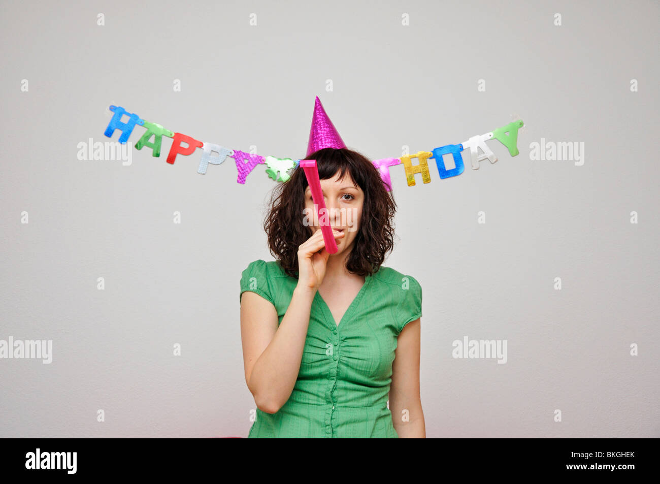 Young woman blowing noise blower Stock Photo - Alamy