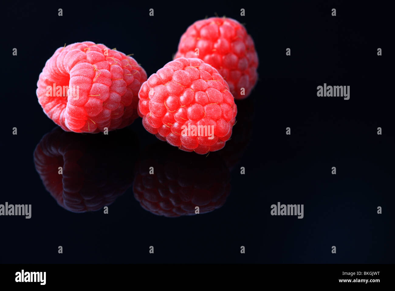 Raspberry fruit on a black background Stock Photo - Alamy