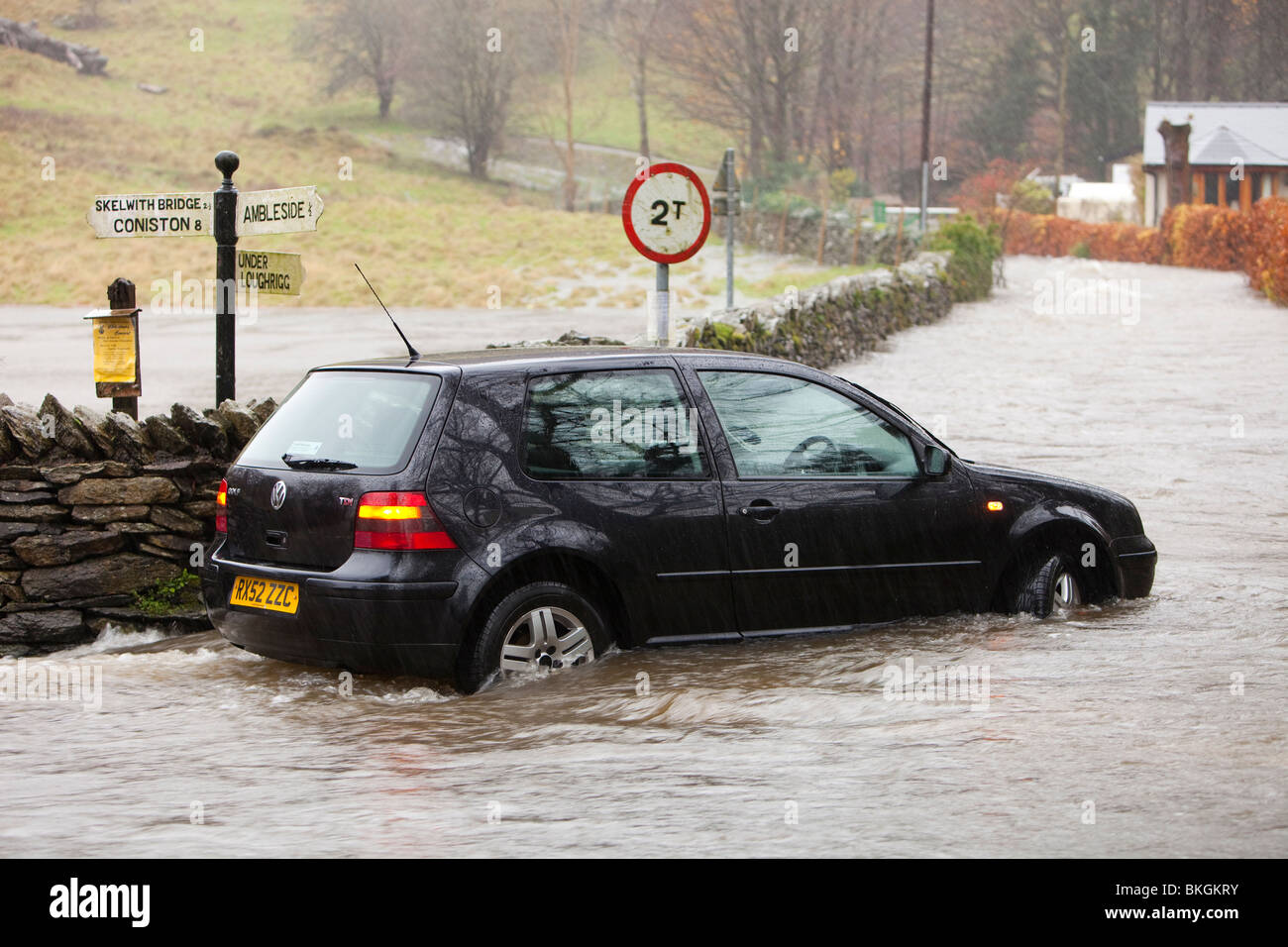 A flooded road in Ambleside and an abandoned car during the devastating