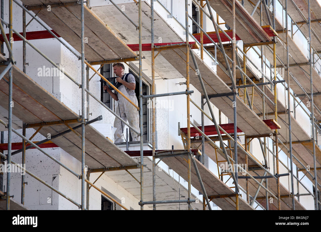 Worker installing thermal insulation on a building, Poznan, Poland Stock Photo
