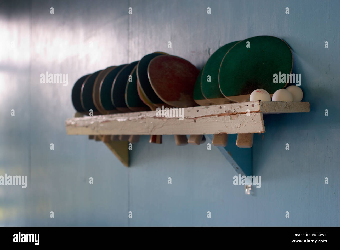 A Wooden Rack Holds Ping Pong Paddles And Balls Stock Photo