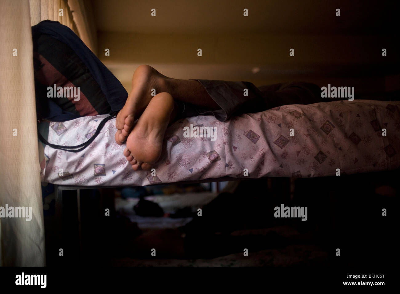 An undocumented Central American migrant sleeps in a shelter for migrants located along the railroad in Mexico City Stock Photo
