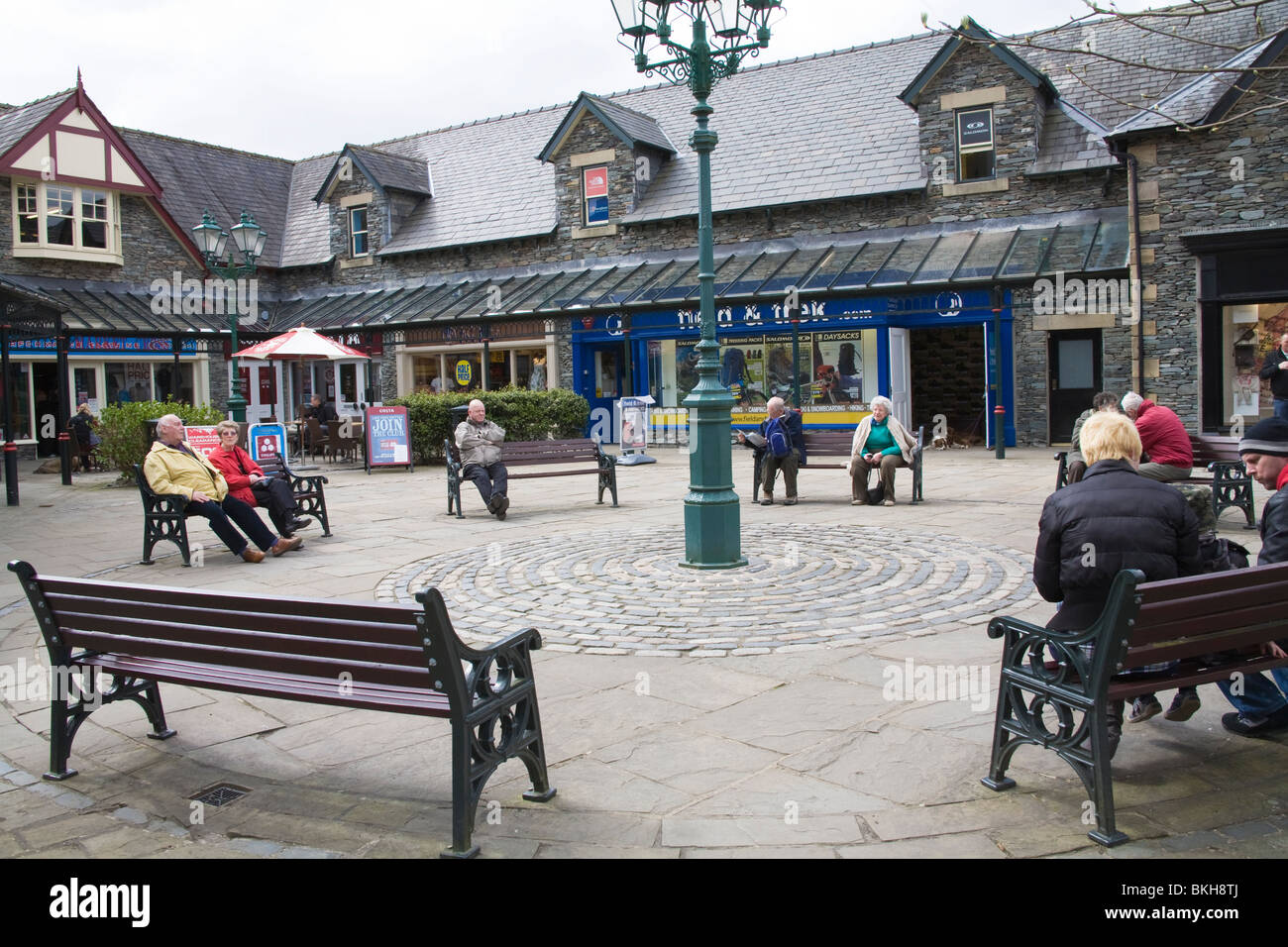 Ambleside Cumbria England UK Visitors resting on the benches in Market Cross in the centre of this Lake District town Stock Photo