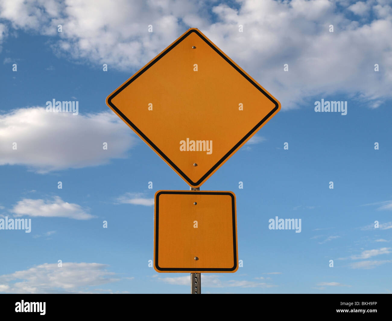 Blank highway caution sign bight blue sky. Stock Photo