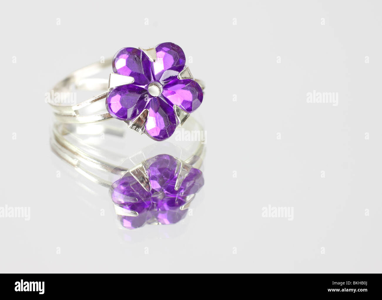 Pretty purple costume jewelry ring on mirrored surface Stock Photo