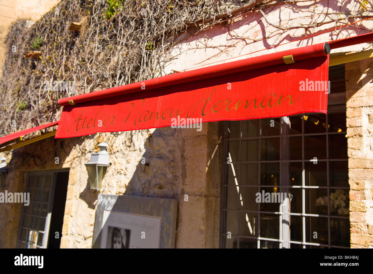 Mougins , Province , paintings or pictures gallery of Atelier Nanou Herman , quaint red blinds on old building draped in vines Stock Photo
