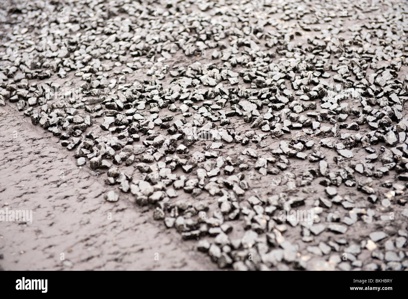 Freshly laid tarmac and road stone before rolling Stock Photo