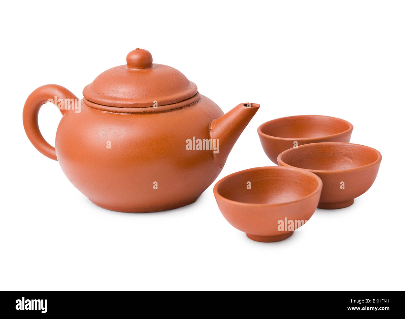 Ceramic ancient oriental teapot and three cups on a white background