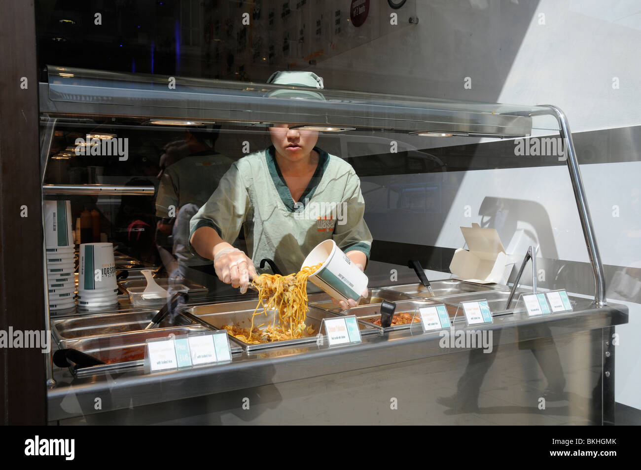 UK SERVING NOODLES AND ORIENTAL FOOD AT A CHINESE TAKE AWAY IN LONDON