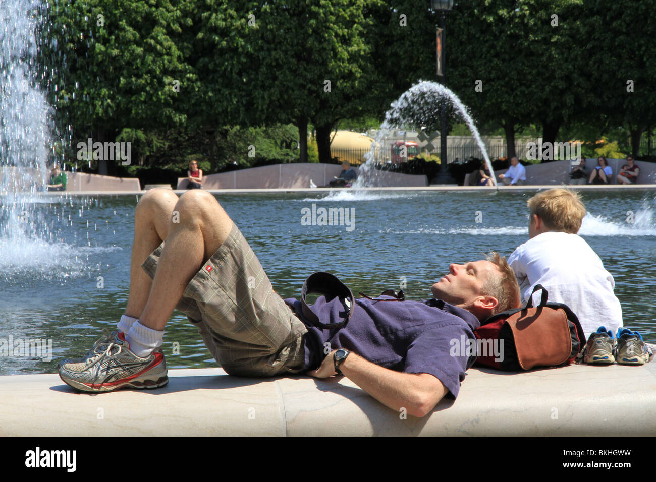 Weary tourists take a rest by the fountain pool of The National Gallery of Art Sculpture Garden in Washington, DC Stock Photo