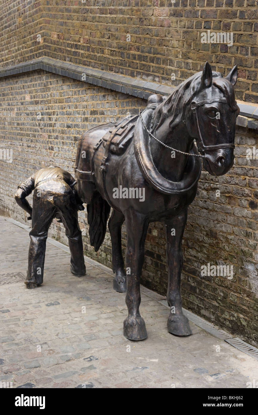A bronze statue of a man shoeing a shire horse in the Horse Hospital Stables market. Stock Photo