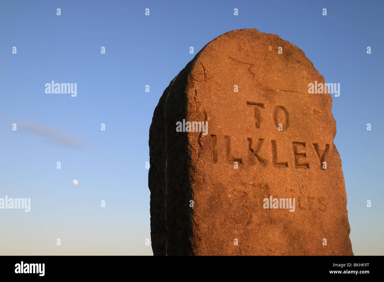 The moon rises over a stone signpost or milestone on "Rombolds" or Ilkley Moor, in West Yorkshire, England, UK Stock Photo