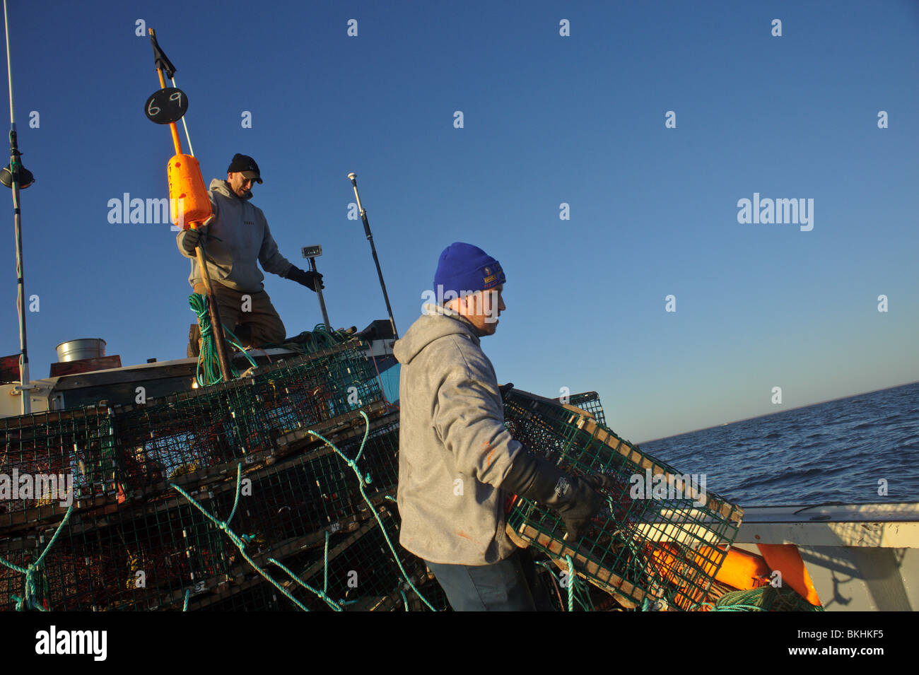 Crew of a lobster boat in the Gulf of St. Lawrence setting traps on opening day of the spring season in New Brunswick, Canada Stock Photo