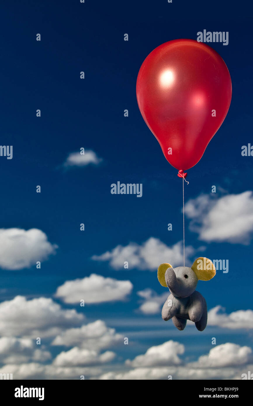 An elephant flying with a red ballon Stock Photo