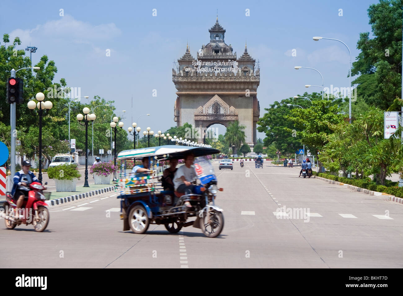 Tuk Tuk on Avenue Lane Xang with Patuxai (Ornate Concrete Archway or the 'Victory Monument'), Vientiane, Laos, Indochina Stock Photo