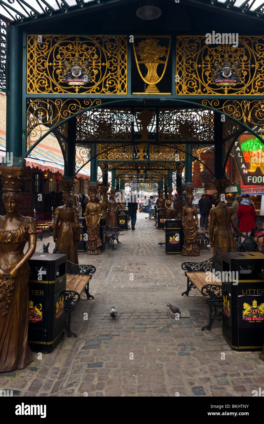 A seating area in a passageway with cobblestones through Horse Hospital Stables market part of Camden market London Stock Photo