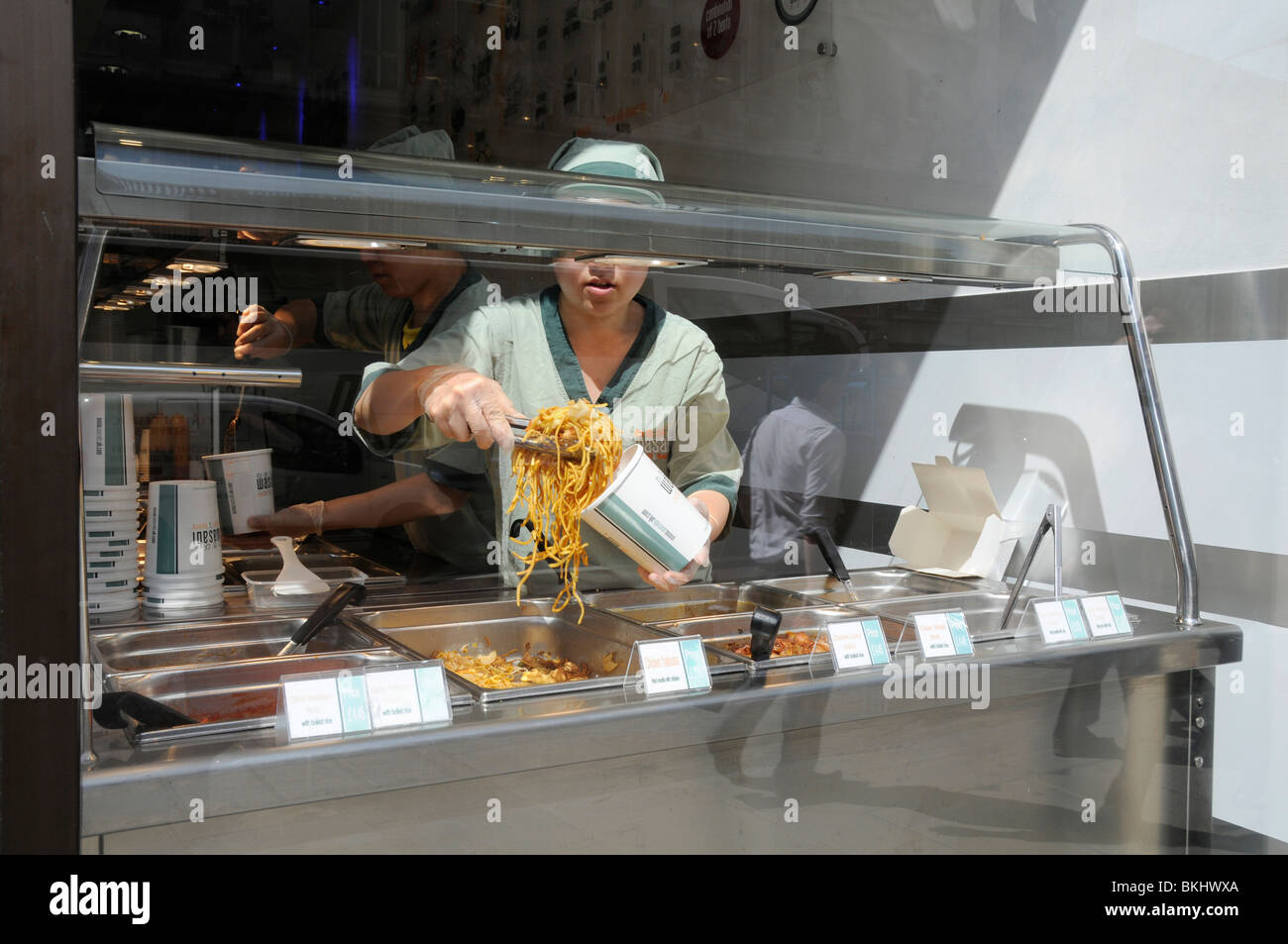 UK SERVING NOODLES AND ORIENTAL FOOD AT A CHINESE TAKE AWAY IN LONDON
