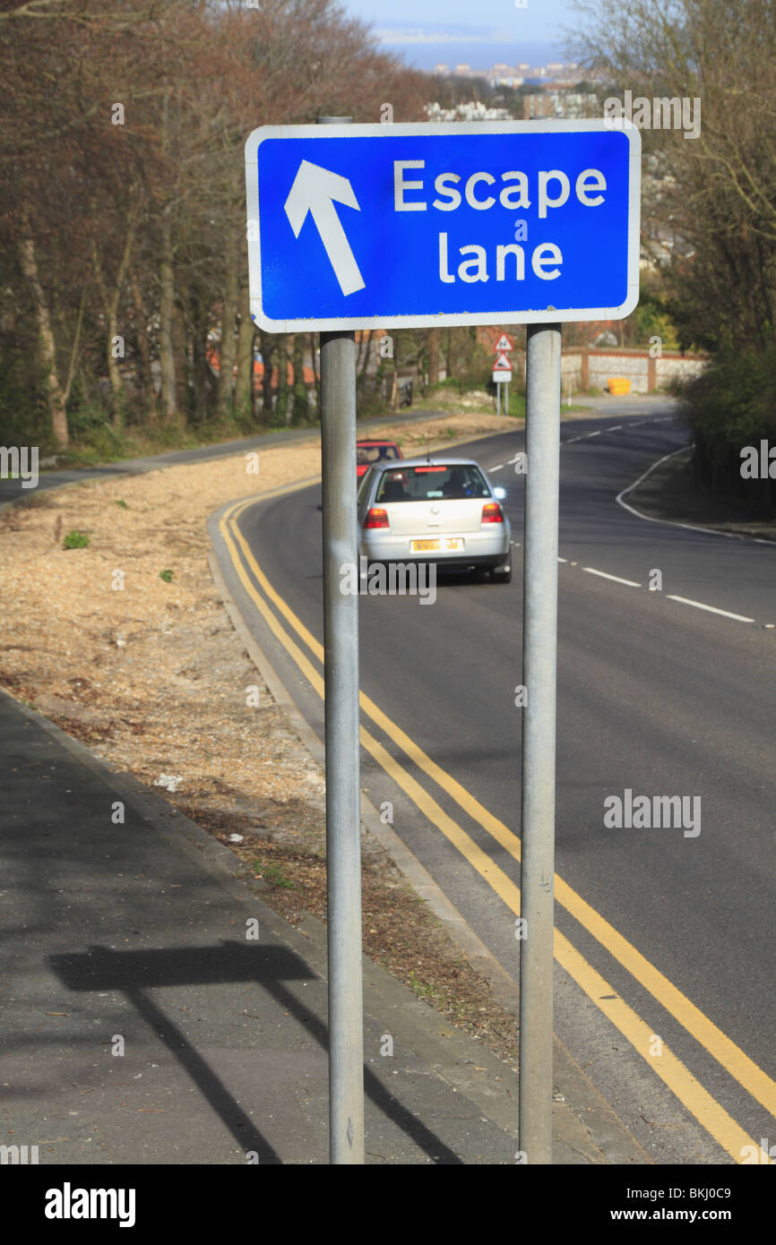 A sign points motorists towards the escape lane on the steep descent from the South Downs into Eastbourne, East Sussex, England Stock Photo