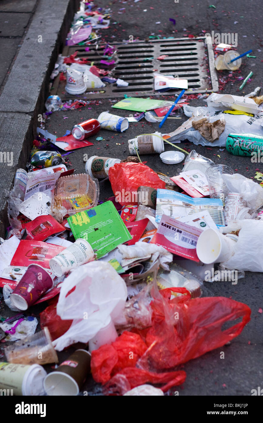 Storm Drain in street with trash in gutter. Stock Photo