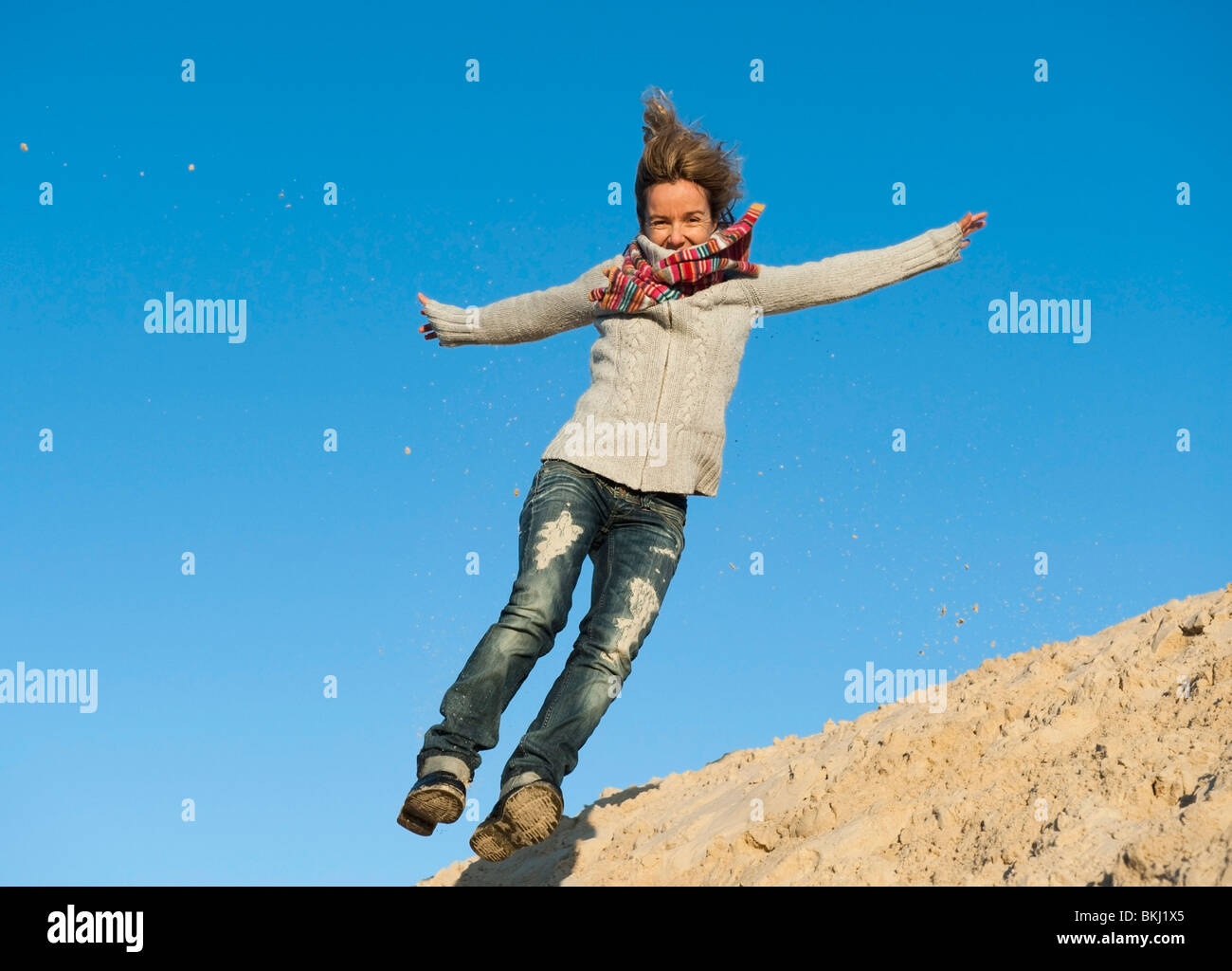 Girl Jumping In The Sand Stock Photo Alamy